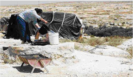 Palestinian woman at primitive cistern